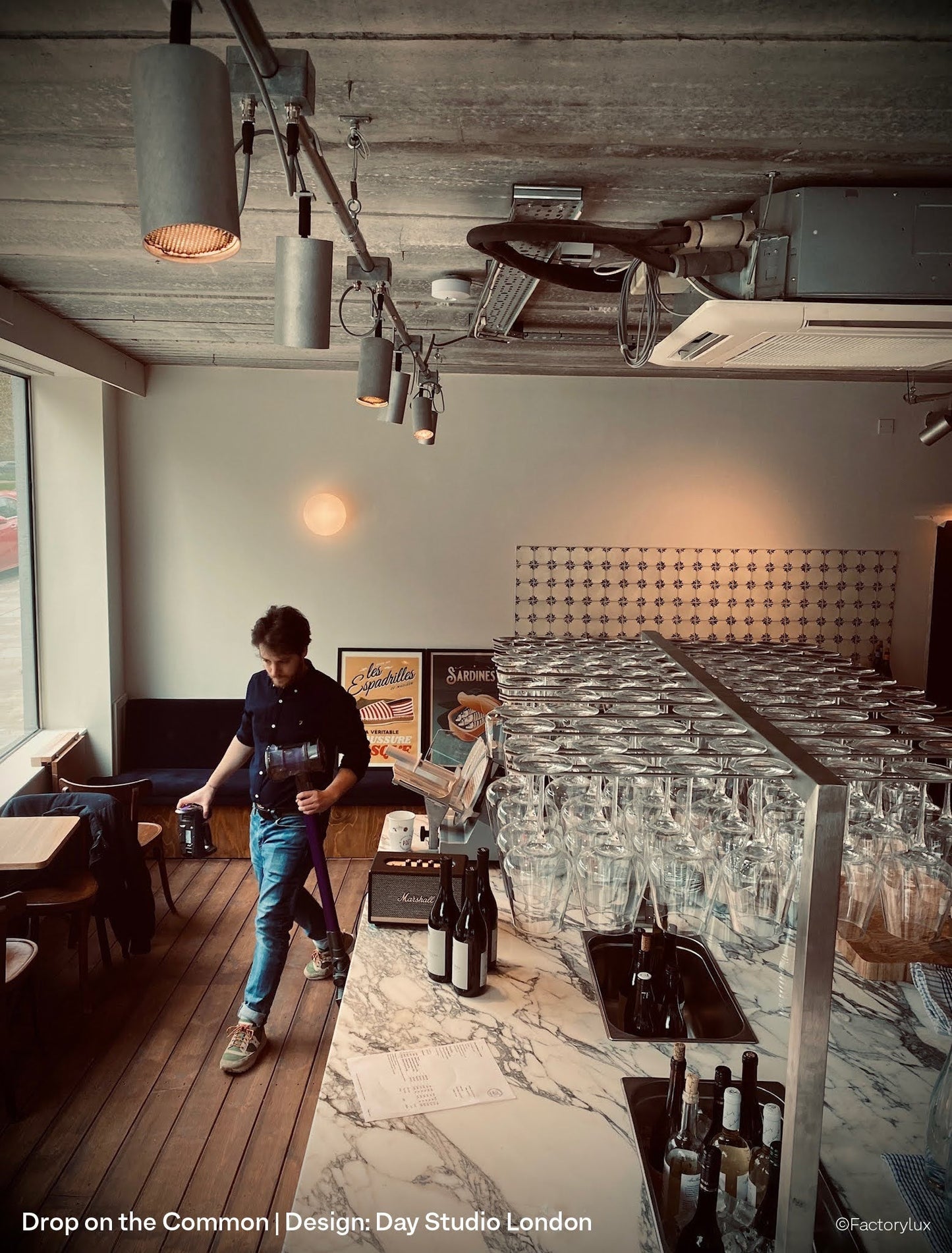 Raw aluminium spotlights ceiling mounted on steel tube in London's Drop On The Common wine bar and shop