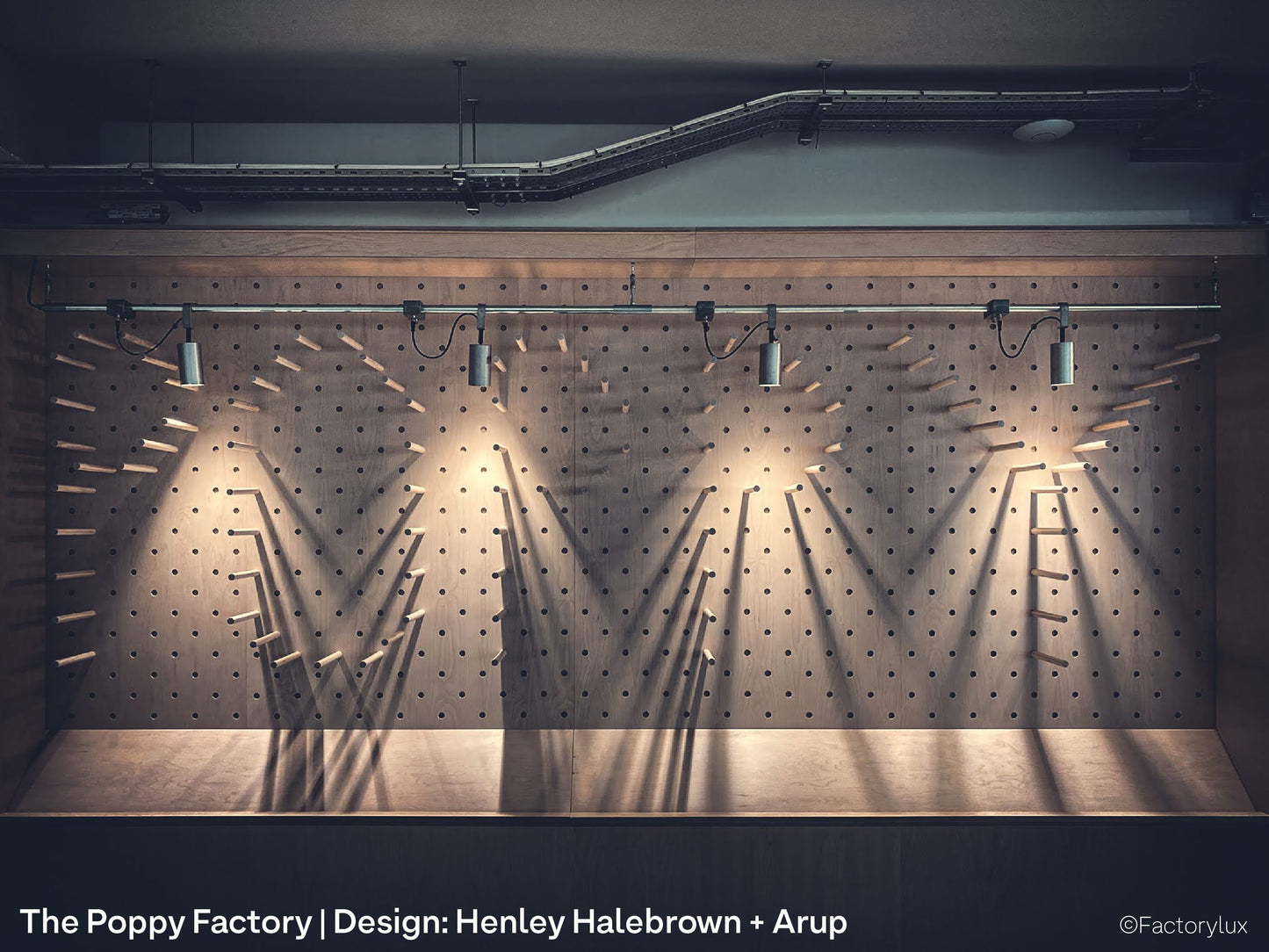 Steel conduit mounted raw metal spotlights in the interior of Royal British Legion's Poppy Factory office and shop