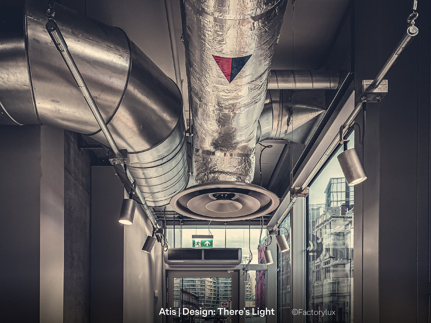 Exposed, open restaurant ceiling with visible HVAC, tubes, pipes cable trays and spotlights on a sustainable alternative to track