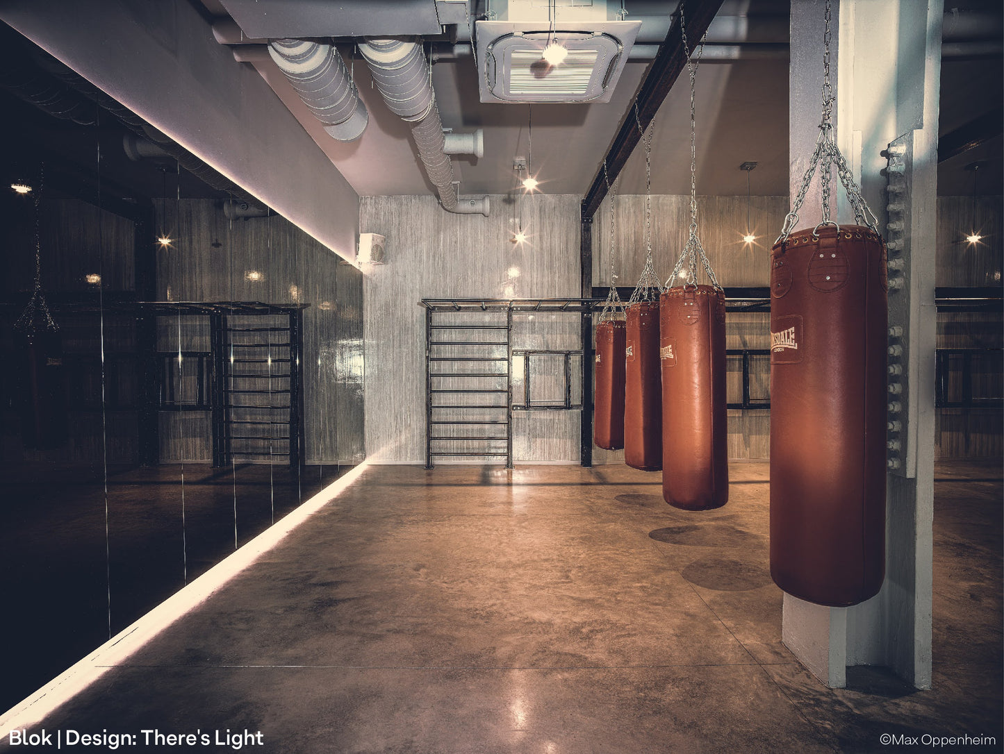 Punch bags, mirror wall, contemporary wooden floor and low-budget architectural pendant lights at BLOK gym in London