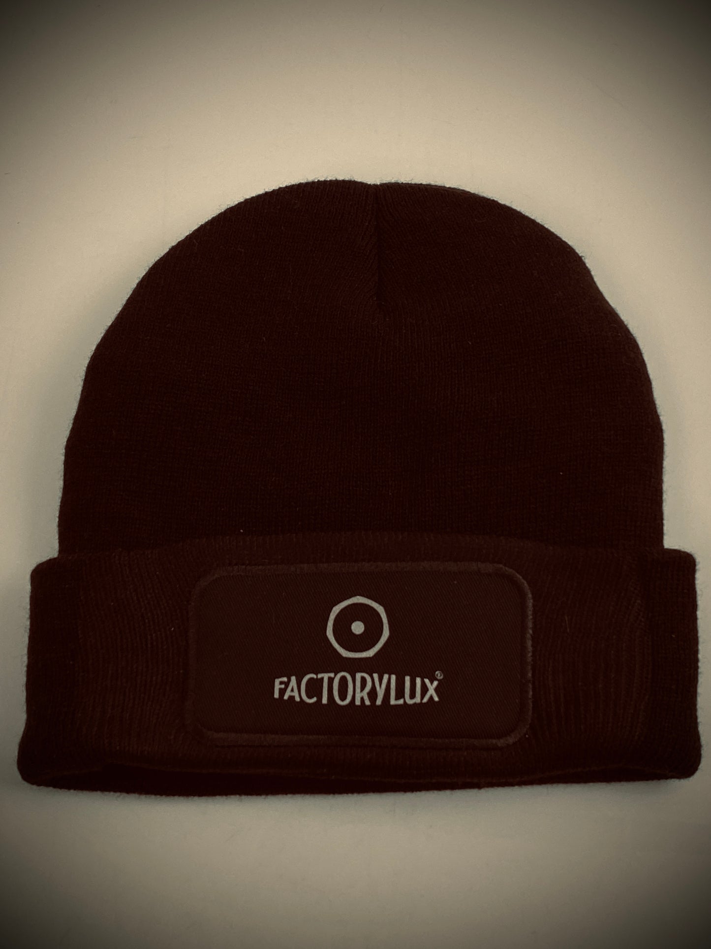Factorylux black hat with logo front, central. Comfortable, warm, stylish AND made from 100% recycled acrylic waste