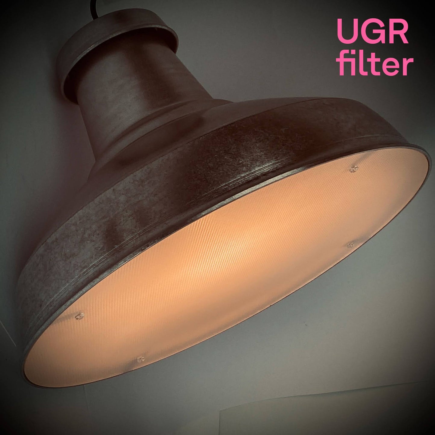 A UGR filter accessory attached to an architectural pendant light that's designed for circular economy