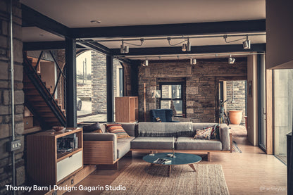 Barn conversion with natural stone, wood, fabric textures and contemporary pendant light and spotlights for reading.