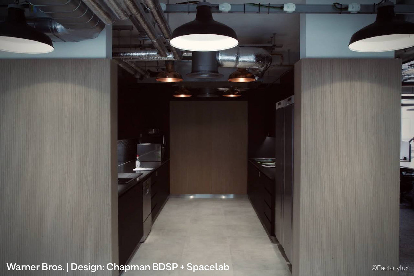 Open plan office lighting fit-out at Warner Bros with cable tray mounted lighting track and sustainable black spotlights